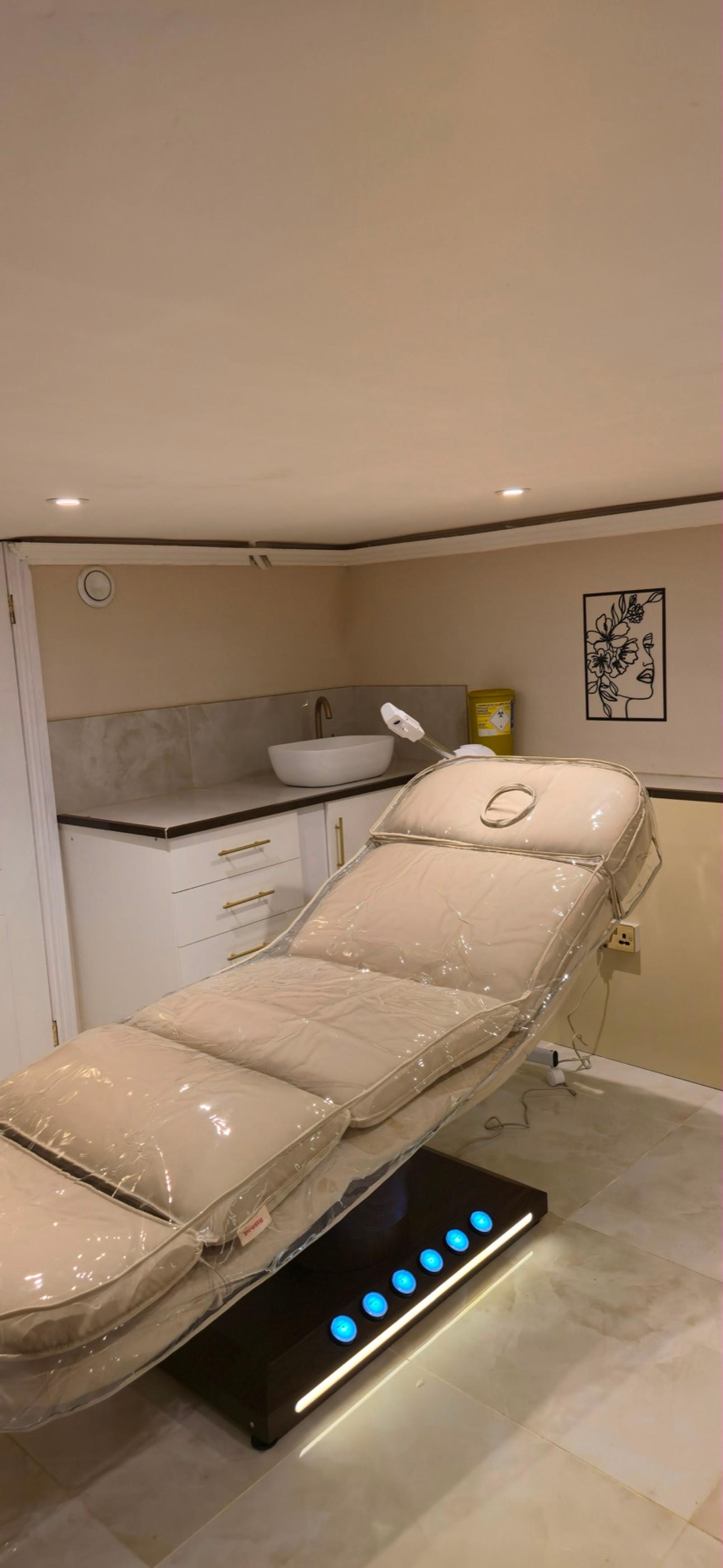 Private treatment room with a facial couch and warm lighting