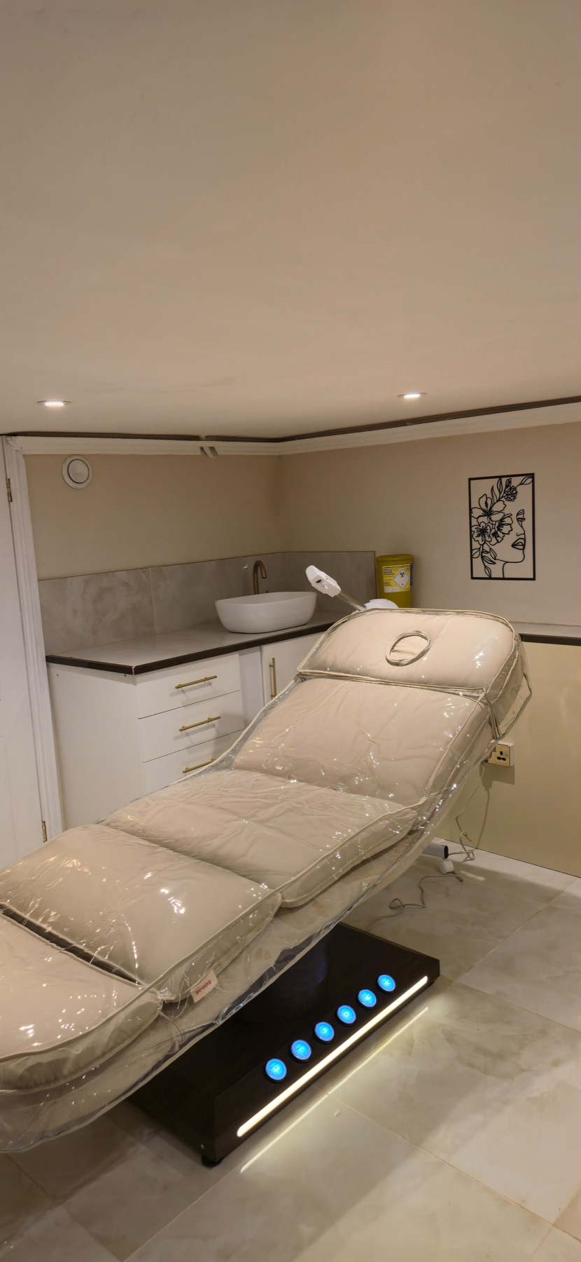 Private treatment room with a facial couch and warm lighting